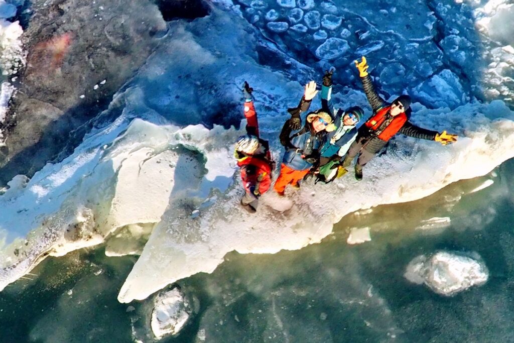 Grupa ludzi stojących na krze.
