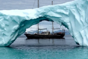 Jacht żaglowy wśród arktycznych gór lodowych