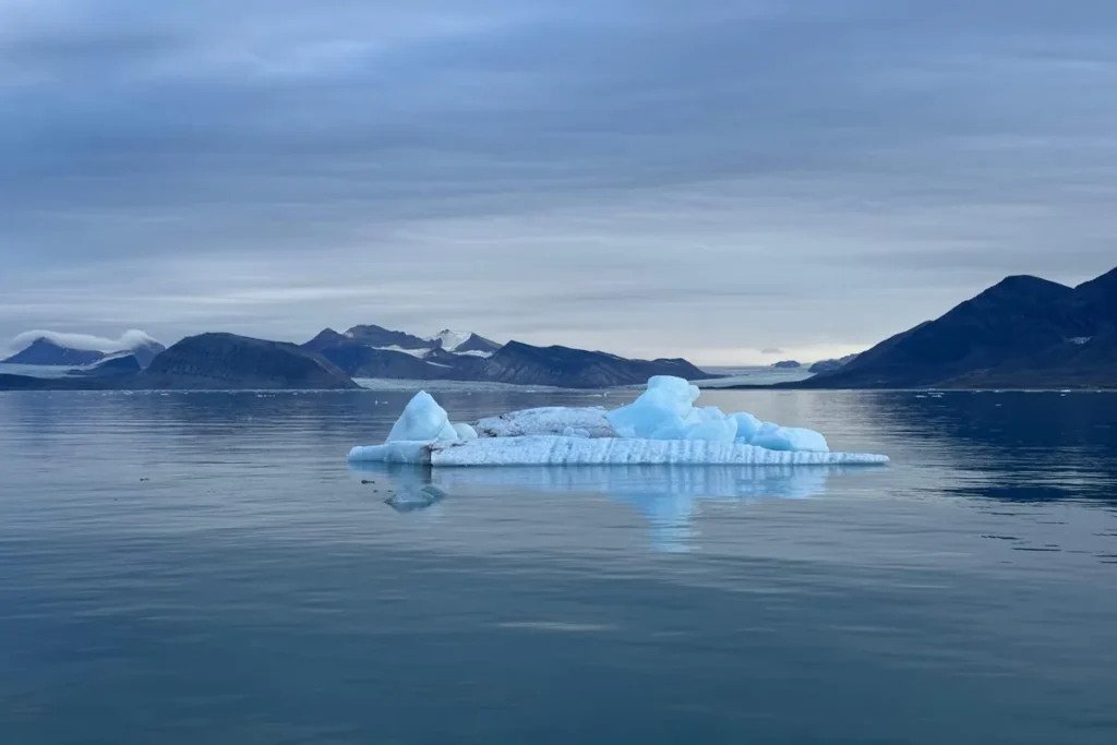 Góra lodowa dryfująca wśród fiordów Svalbardu – cisza i błękit Arktyki