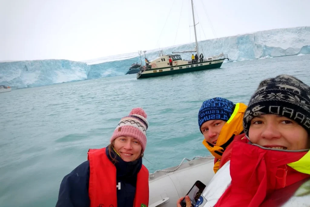 Załoganci w pontonie na tle lodowca Austfonna, Svalbard